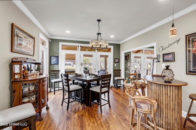 dining room with recessed lighting, french doors, crown molding, and wood finished floors