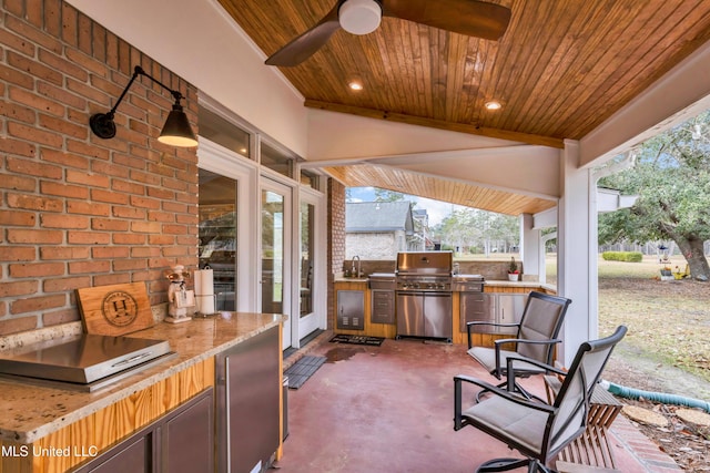 view of patio featuring a grill, a ceiling fan, and an outdoor kitchen