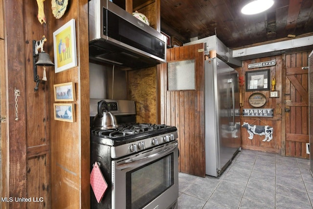 6131 Jenness Rd, Pearlington, MS 39572 - kitchen with stainless steel appliances, wood walls, light tile patterned floors, and wooden ceiling