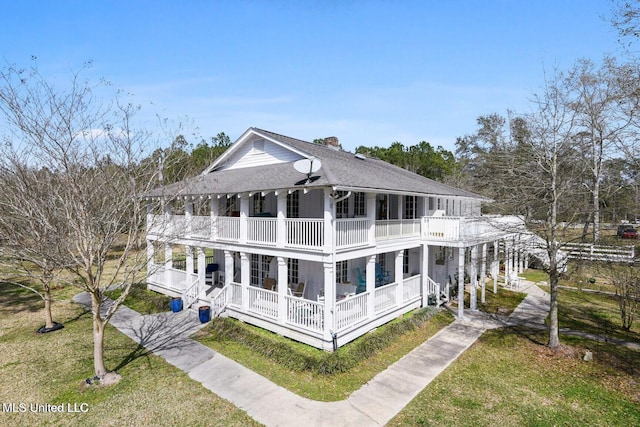 6131 Jenness Rd, Pearlington, MS 39572 - rear view of house with a balcony, covered porch, a chimney, a yard, and driveway