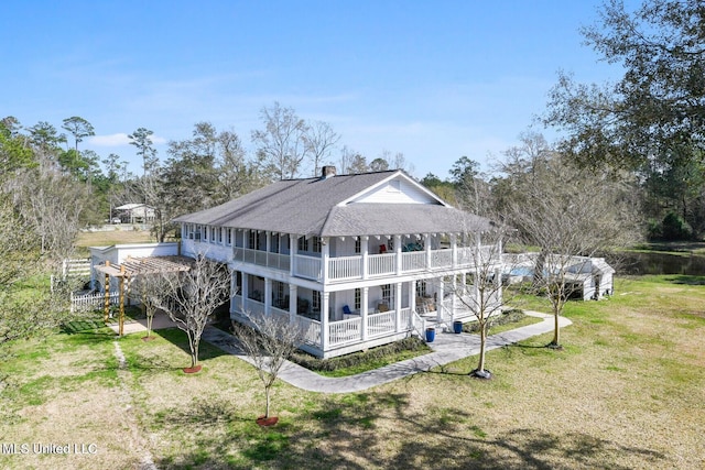 6131 Jenness Rd, Pearlington, MS 39572 - back of property featuring a balcony, roof with shingles, a yard, and a chimney