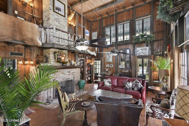 6131 Jenness Rd, Pearlington, MS 39572 - living room featuring high vaulted ceiling, wooden walls, wood ceiling with exposed beams, healthy amount of natural light, and wood finished floors