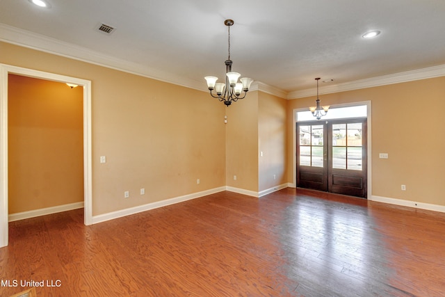 spare room featuring dark hardwood / wood-style floors, ornamental molding, and french doors