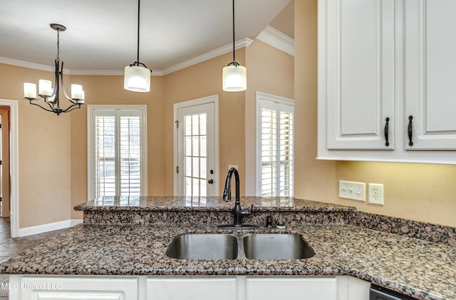 kitchen featuring white cabinets, sink, plenty of natural light, and hanging light fixtures