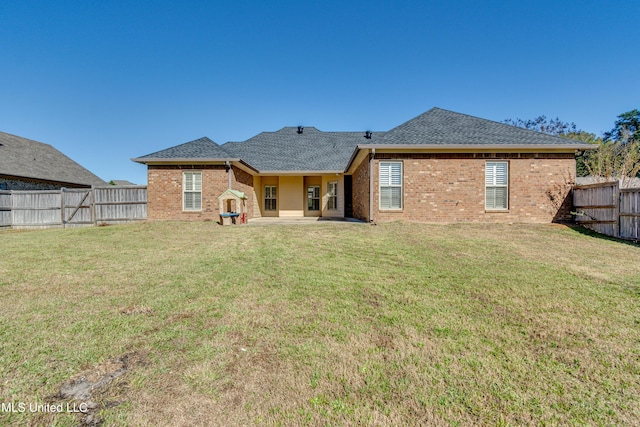 back of property with a yard and a patio