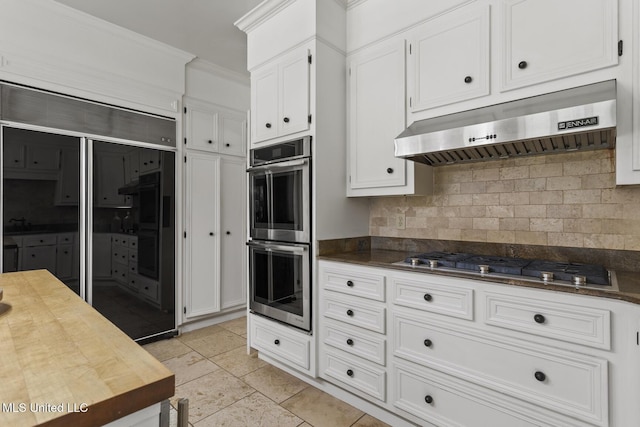 13 Highland Meadows Dr, Jackson, MS 39211 - kitchen featuring appliances with stainless steel finishes, under cabinet range hood, decorative backsplash, crown molding, and white cabinetry