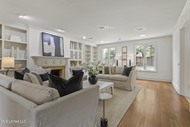 13 Highland Meadows Dr, Jackson, MS 39211 - living area featuring crown molding, built in features, light wood finished floors, a brick fireplace, and recessed lighting