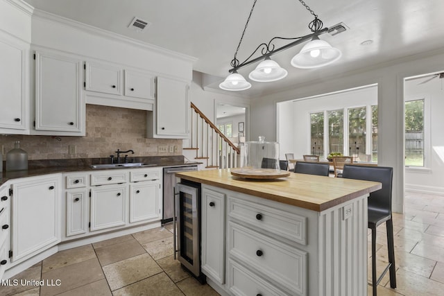 13 Highland Meadows Dr, Jackson, MS 39211 - kitchen with wooden counters, beverage cooler, white cabinetry, a kitchen bar, and crown molding