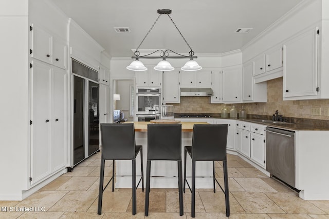 13 Highland Meadows Dr, Jackson, MS 39211 - kitchen featuring appliances with stainless steel finishes, under cabinet range hood, white cabinetry, backsplash, and crown molding