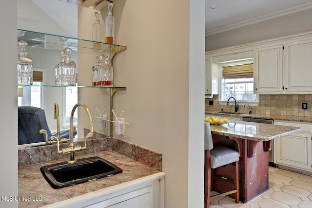 bar featuring decorative backsplash, dishwasher, crown molding, and a sink