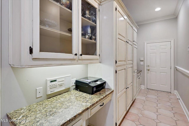 kitchen with glass insert cabinets, baseboards, ornamental molding, light stone counters, and recessed lighting