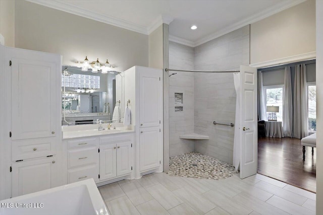 full bath featuring connected bathroom, vanity, crown molding, and a tile shower