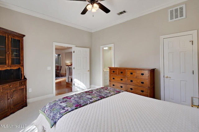 carpeted bedroom featuring visible vents, baseboards, and crown molding