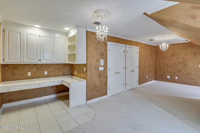 kitchen with light carpet, a notable chandelier, ornamental molding, and white cabinetry