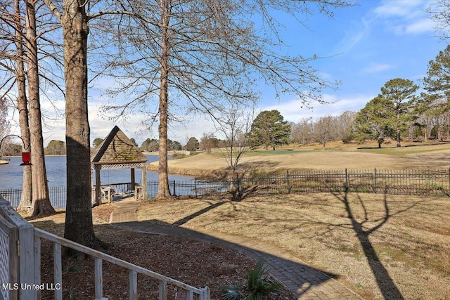 view of yard featuring a gazebo, fence, and a water view