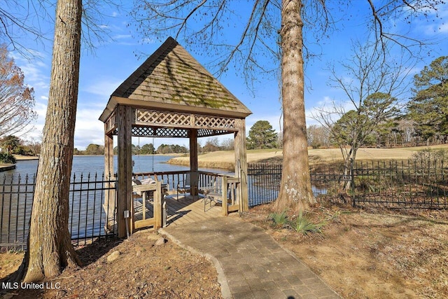 view of dock featuring a gazebo, a water view, and fence