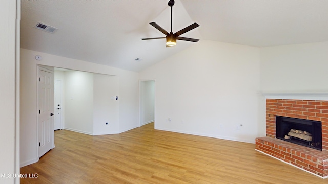 unfurnished living room with vaulted ceiling, ceiling fan, a fireplace, and light hardwood / wood-style floors