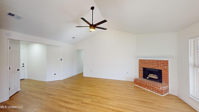 unfurnished living room featuring light hardwood / wood-style flooring, a fireplace, lofted ceiling, and ceiling fan