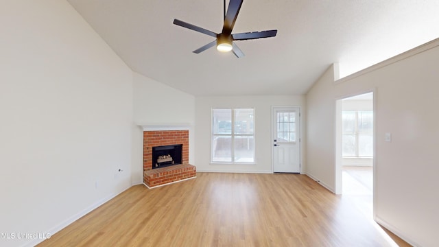 unfurnished living room featuring lofted ceiling, a fireplace, ceiling fan, and light wood-type flooring