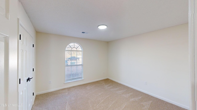 unfurnished room featuring light colored carpet