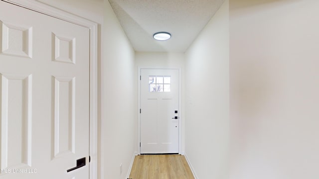 entryway featuring light hardwood / wood-style flooring and a textured ceiling