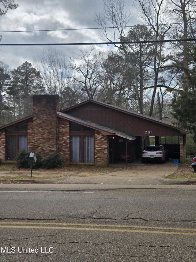 exterior space featuring a chimney and a carport