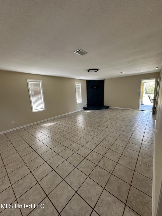 spare room with light tile patterned floors, baseboards, and visible vents