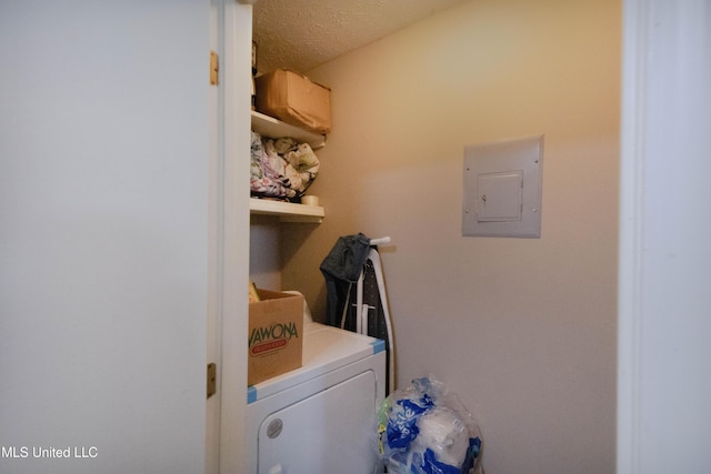 laundry area with washer / clothes dryer, electric panel, and a textured ceiling