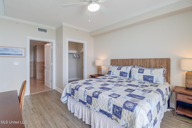 2060 Beach Blvd Unit 1602, Biloxi, MS 39531 - bedroom featuring wood finished floors, a closet, ceiling fan, ornamental molding, and a walk in closet