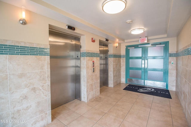 2060 Beach Blvd Unit 1602, Biloxi, MS 39531 - bathroom with tile walls, elevator, tile patterned floors, and a wainscoted wall