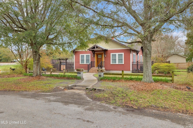 bungalow featuring a front lawn and fence