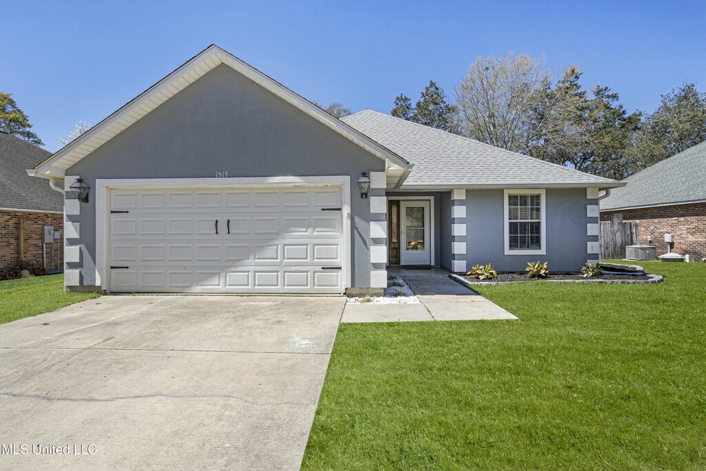 1517 Porpoise Dr, Ocean Springs, MS 39564 - ranch-style home featuring driveway, roof with shingles, stucco siding, a front lawn, and a garage