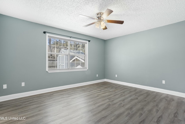 empty room with wood finished floors, a ceiling fan, and baseboards