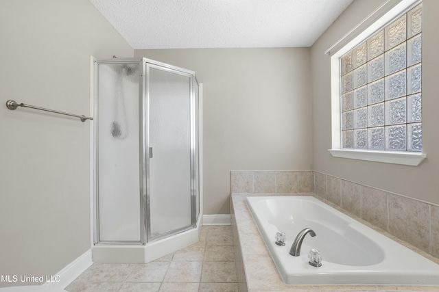 bathroom with a shower stall, baseboards, a bath, tile patterned floors, and a textured ceiling