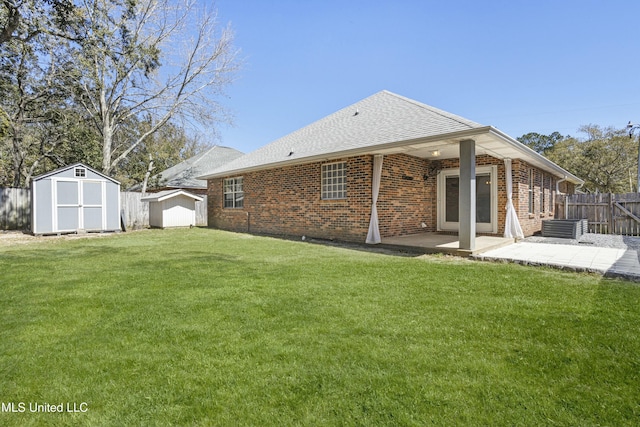 back of property featuring brick siding, fence, a shed, a lawn, and a patio