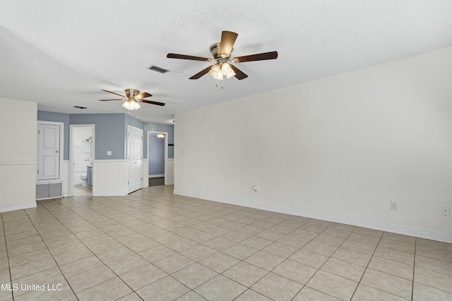 unfurnished room featuring a ceiling fan, visible vents, and a textured ceiling