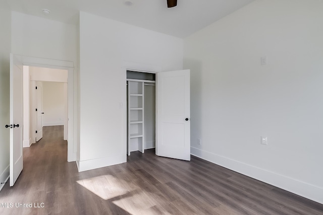 unfurnished bedroom featuring dark hardwood / wood-style floors, ceiling fan, and a closet