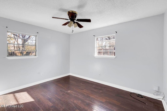 unfurnished room featuring a ceiling fan, baseboards, dark wood finished floors, and a textured ceiling