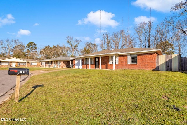 ranch-style house with a garage, brick siding, a front lawn, and fence