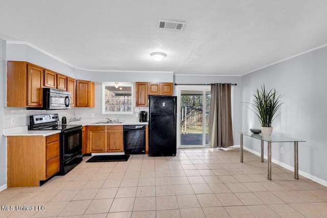 kitchen with light tile patterned floors, plenty of natural light, visible vents, light countertops, and black appliances