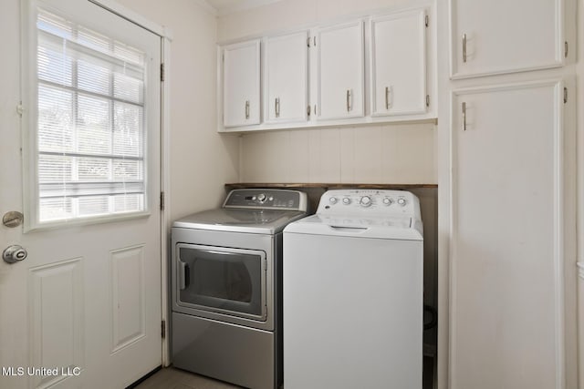 washroom with washing machine and dryer and cabinets