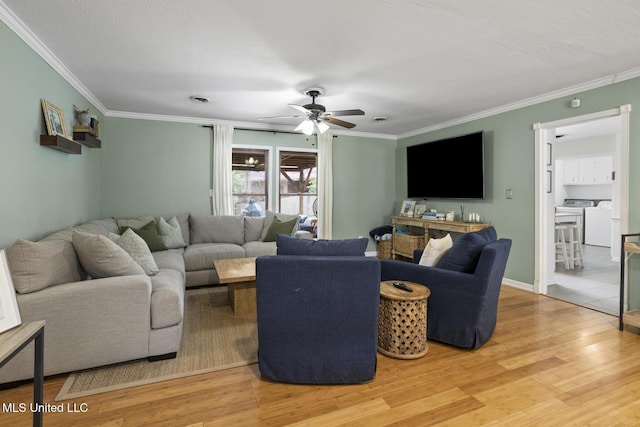 living room with ceiling fan, crown molding, washer and clothes dryer, and wood-type flooring