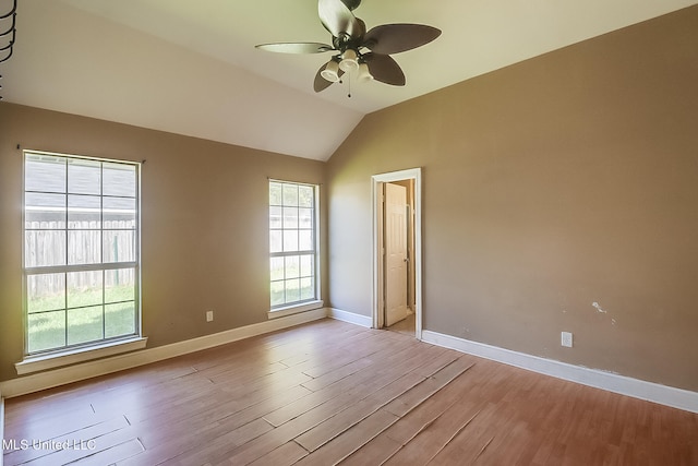 empty room featuring vaulted ceiling, light hardwood / wood-style flooring, and ceiling fan