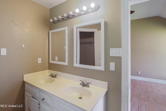 bathroom featuring hardwood / wood-style floors, vanity, and lofted ceiling