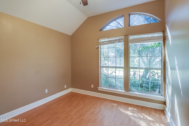 spare room featuring light wood-type flooring, vaulted ceiling, and ceiling fan