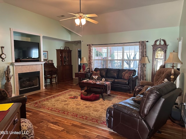 living room with a tile fireplace, hardwood / wood-style floors, ceiling fan, and lofted ceiling