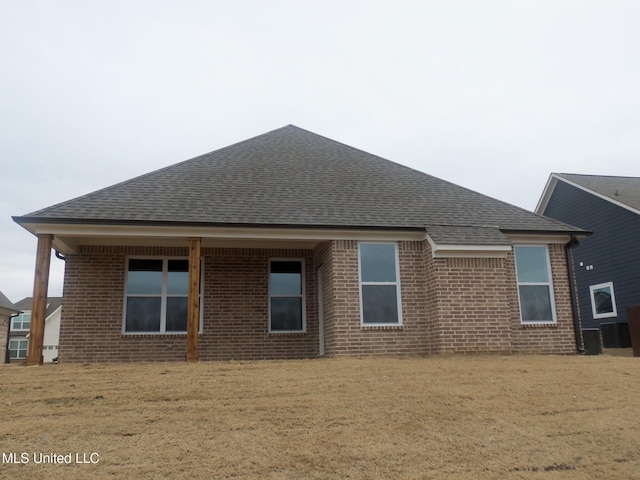 rear view of house with a lawn and central air condition unit