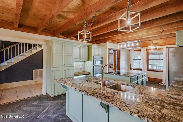 kitchen with sink, decorative light fixtures, beam ceiling, light stone counters, and stainless steel appliances