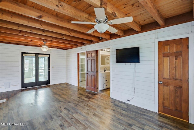 empty room with beam ceiling, dark hardwood / wood-style flooring, wooden walls, and wood ceiling