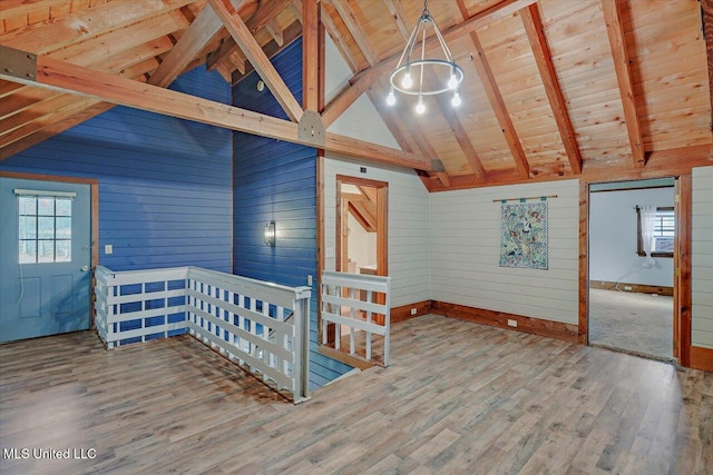 interior space with beam ceiling, wooden walls, plenty of natural light, and wood-type flooring